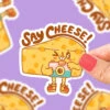 Say Cheese Vinyl Sticker(Say Cheese Vinyl Sticker) 1 Say Cheese Vinyl Sticker(Say Cheese Vinyl Sticker) -Curious Bear Toys say cheese funny cheesy sticker pun food sticker by turtles soup vinyl sticker cheese lover cheddar cheese block photo photographer film 1296x 572f9524 704c 425a ad9f 60577a2741a2